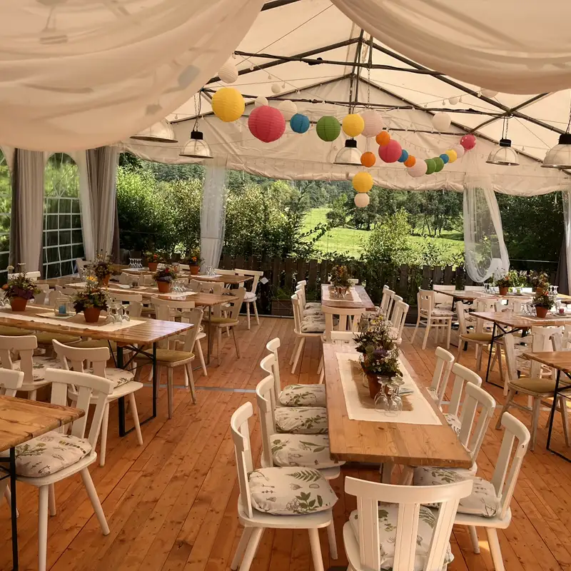Sommerliches Festzelt für Feiern im Westerwald Festlich geschmücktes Zelt für Sommerparty oder Feier im Westerwald mit Holzboden, bunten Lampions und einladender Tischdekoration.